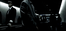 a man wearing sunglasses stands in a dark room