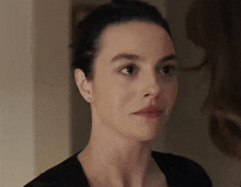 a close up of a woman 's face with a slight smile on her face