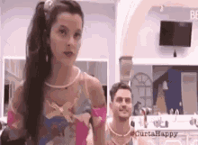 a man and a woman are standing next to each other in a kitchen .