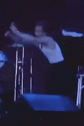 a man is playing drums on a stage in front of a microphone .