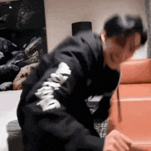 a person wearing a black sweatshirt with the word supreme on the sleeves
