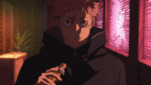 a man in a black jacket is holding a piece of wood