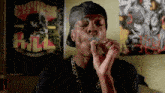 a man is smoking a cigarette in front of a poster that says cypress hill