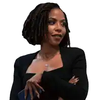 a woman with dreadlocks is wearing a black jacket and holding a blue phone