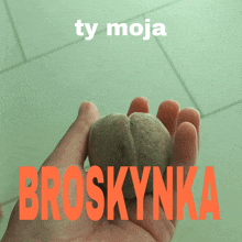 a person is holding a peach in their hand with the words ty moja broskynka above it