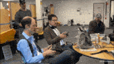 a raccoon sits on a table with a group of people