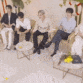 a group of people are sitting in chairs in a room