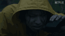 a person in a yellow raincoat with a netflix logo on the bottom right