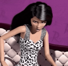 a barbie doll is sitting on a couch wearing a black and white leopard print dress