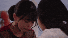 two women are kissing each other on the forehead in a close up of their faces .