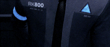 a man is wearing a suit and tie with the name rk800 on it .