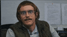 a man wearing glasses and a wig is sitting in front of a paper that says " rules " on it