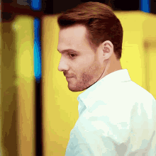 a man with a beard wearing a white shirt is smiling