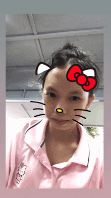 a girl wearing a pink shirt with a hello kitty on it