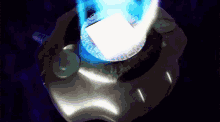 a silver object with a blue light coming out of the top