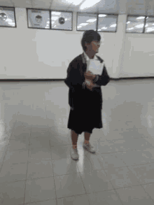 a woman standing in a room holding a piece of paper in her hand
