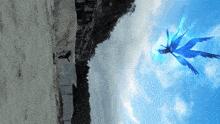 a blue bird is flying in the sky above a sandy beach