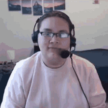 a man wearing glasses and headphones is sitting in front of a computer .