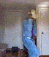a person in a blue suit and tie is standing in a room
