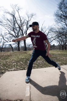 a man throwing a frisbee wearing a dark ace shirt
