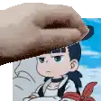 a close up of a person 's hand holding a cartoon character 's head .