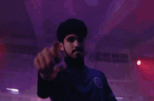 a man with a beard is pointing at the camera in front of a crowd of people
