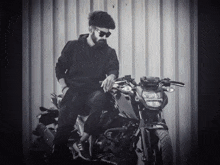 a man with a beard is sitting on a black motorcycle