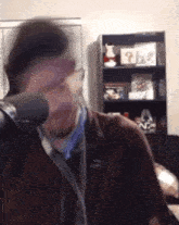 a man is talking into a microphone while wearing headphones .