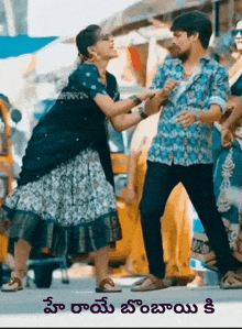 a man and a woman are standing next to each other on a street in a scene from a movie .