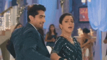 a man and a woman are dancing together in a room at a party .