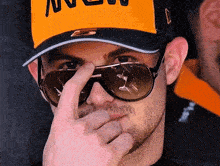 a man wearing sunglasses and a hat that says ' mclaren ' on it