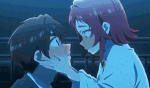 a girl with red hair touches a boy 's face with her hand