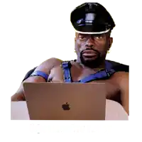 a shirtless man is sitting in front of an apple laptop computer