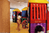 a child is playing in a playground with a sign that says entry