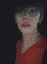 a close up of a person 's face with blue hair wearing a red shirt .