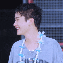 a man wearing a hawaiian lei around his neck and a shirt that says ' california ' on it