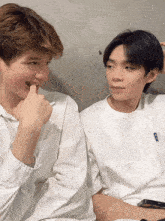 two young men are sitting next to each other and one of them has a tik tok account