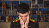 a man is covering his ears with his hands in front of a shelf full of action figures