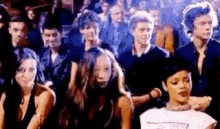a crowd of people are sitting in a stadium watching a performance .