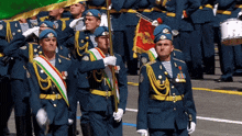a group of men in military uniforms marching with a drum