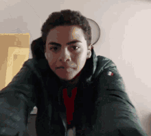 a young man wearing a green jacket with a tommy hilfiger logo