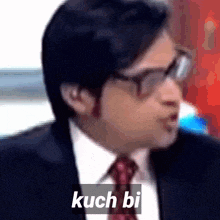 a man in a suit and tie says kuch bi in white letters