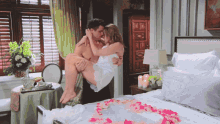 a man is carrying a woman in his arms over a bed