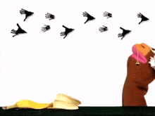 a hand is holding a balloon in front of a bunch of handprints