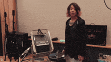 a woman in a black nike jacket stands in front of a microphone