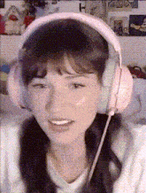 a girl wearing pink headphones looks at the camera