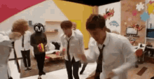 a group of people are standing in a room dancing .