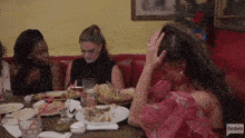 a group of women are sitting at a table with bravo written on the bottom right
