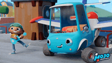a boy playing a guitar next to a blue toy truck that says mojo on the side