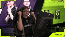 a man in a heretic shirt sitting in front of a computer
